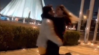 Ein junges Paar tanzt und umarmt sich vor Freiheitsturm in Teheran.