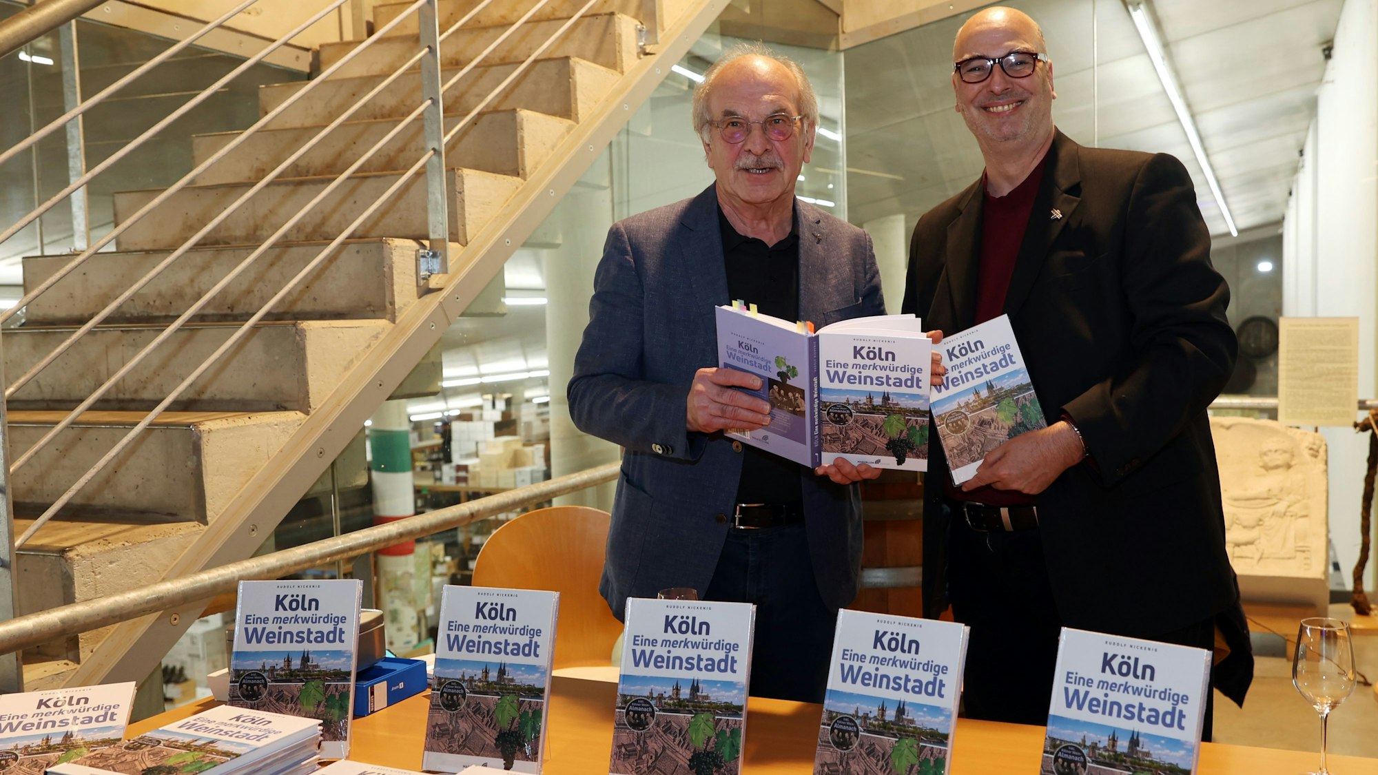 Rudolf Nickenig und Frank Tewes vom Marzellen Verlag halten beide ein Exemplar des neuen Buchs in den Händen.