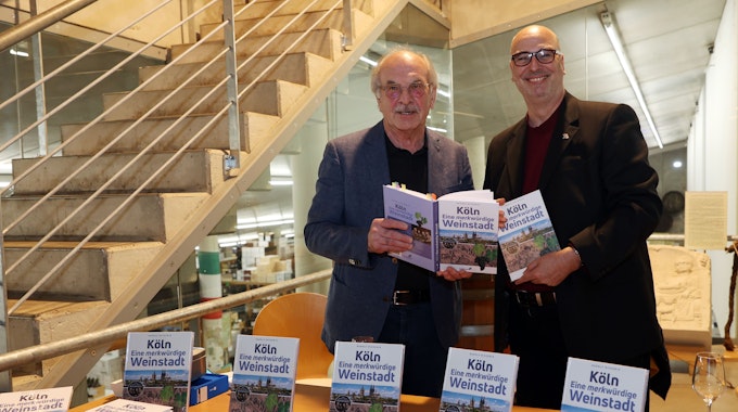 Rudolf Nickenig und Frank Tewes vom Marzellen Verlag halten beide ein Exemplar des neuen Buchs in den Händen.
