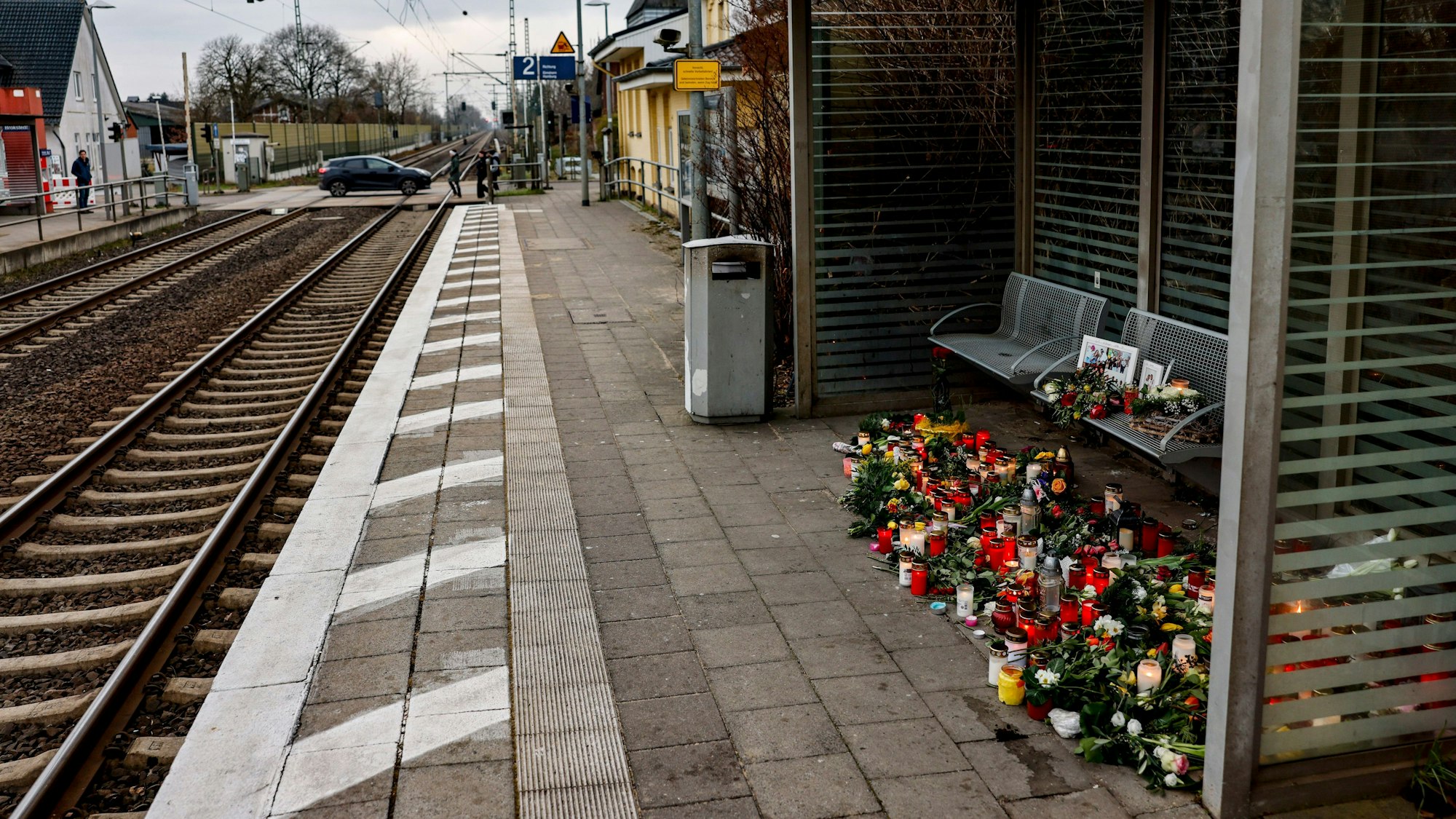 Brokstedt: Blumen, Kerzen und verschiedene Bilder sind im Wartehäuschen am Bahnhof zum Gedenken an die Opfer der Messerattacke niedergelegt.