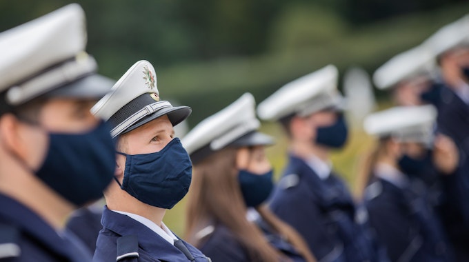 Kommissar-Anwärter und -Anwärterinnen tragen bei einer Vereidigungsfeier der Polizeien Köln, Bonn und Aachen Alltagsmasken.&nbsp;