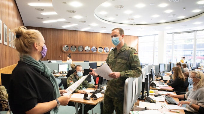 Soldaten der Bundeswehr helfen in einem Großraumbüro der Verwaltung des Rheinisch-Bergischen Kreises.