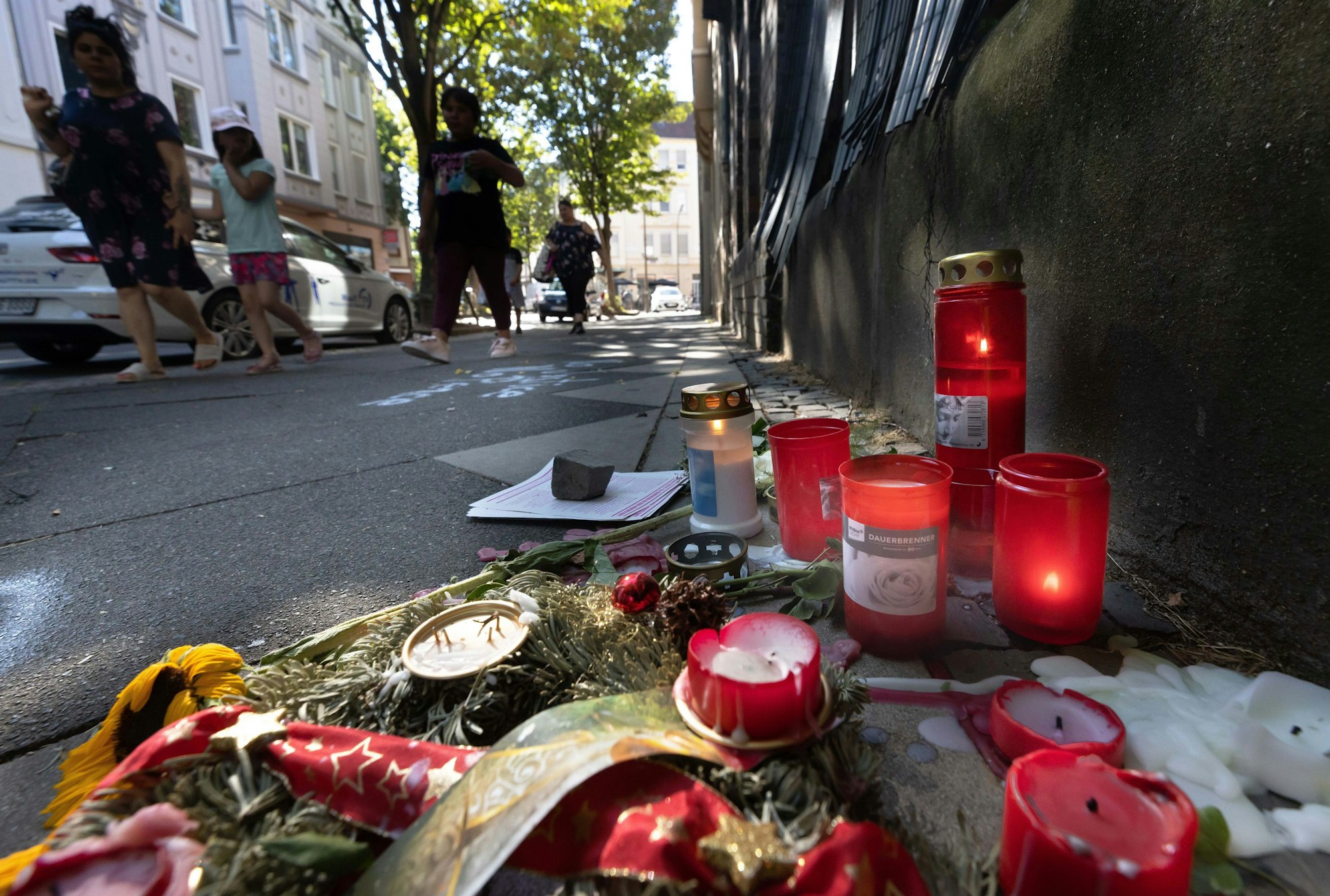 10.08.2022, Nordrhein-Westfalen, Dortmund: Trauer-Blumen und Kerzen erinnern an den Tod eines 16-jährigen Jugendlichen. Auch Tage nach den tödlichen Schüssen aus einer Polizei-Maschinenpistole auf einen 16-Jährigen wird heftig über den Fall diskutiert. Foto: Dieter Menne/dpa +++ dpa-Bildfunk +++