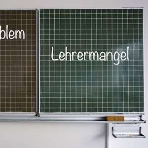 Auf einer Schultafel stehen rechts der Begriff „Lehrermangel“ und links „Schulproblem“, beides in Kreideschrift.