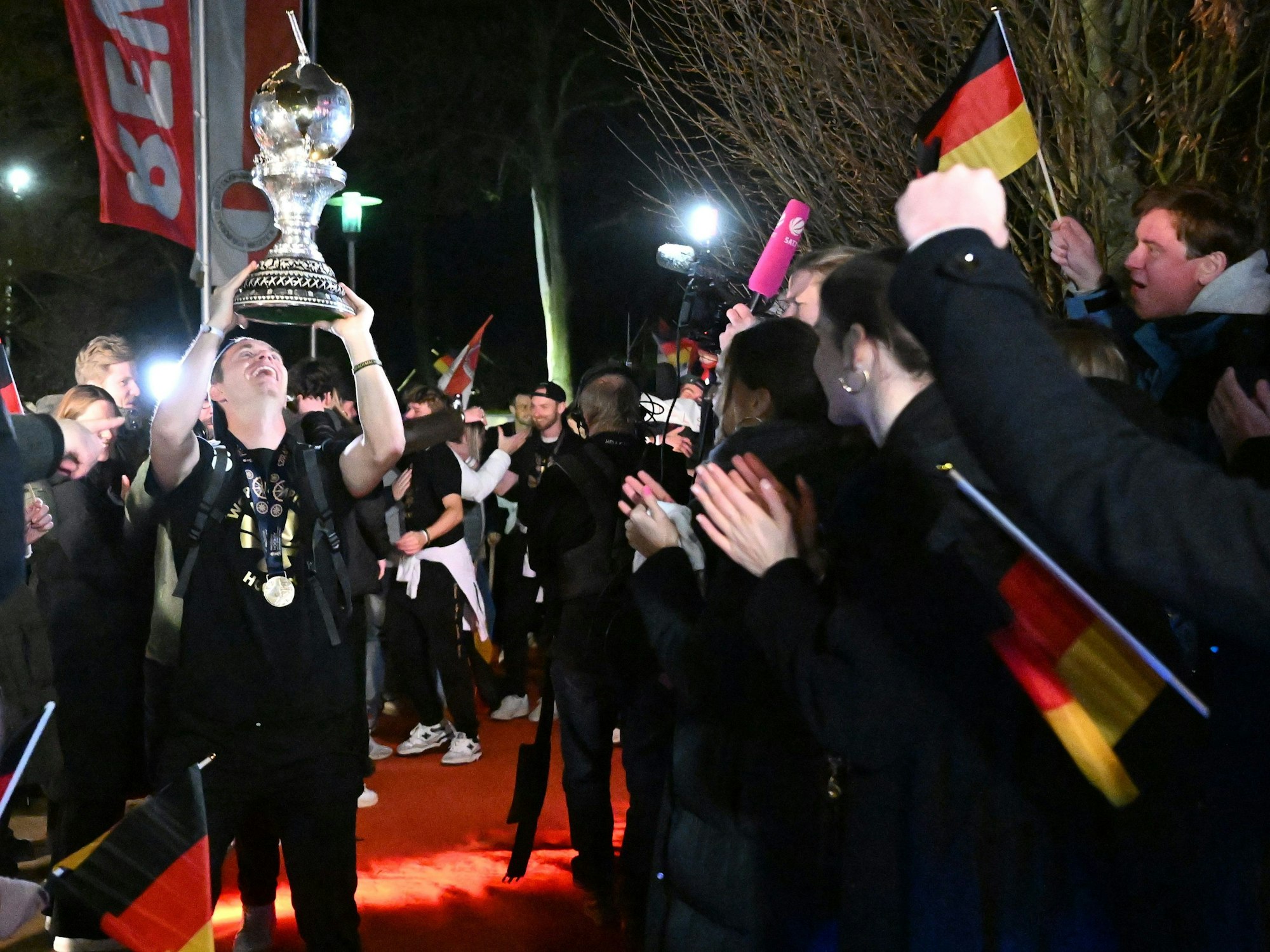 Kapitän Mats Grambusch (l) hebt den Weltmeister-Pokal in die Höhe. 