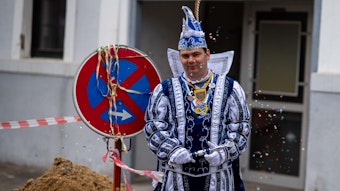 Der Roitzheimer Karnevalsprinz steht in seinem Ornat vor der Baustelle des Dorfsaals.