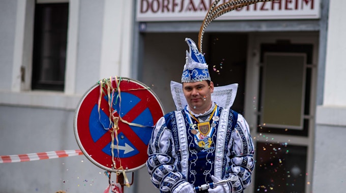 Der Roitzheimer Karnevalsprinz steht in seinem Ornat vor der Baustelle des Dorfsaals.