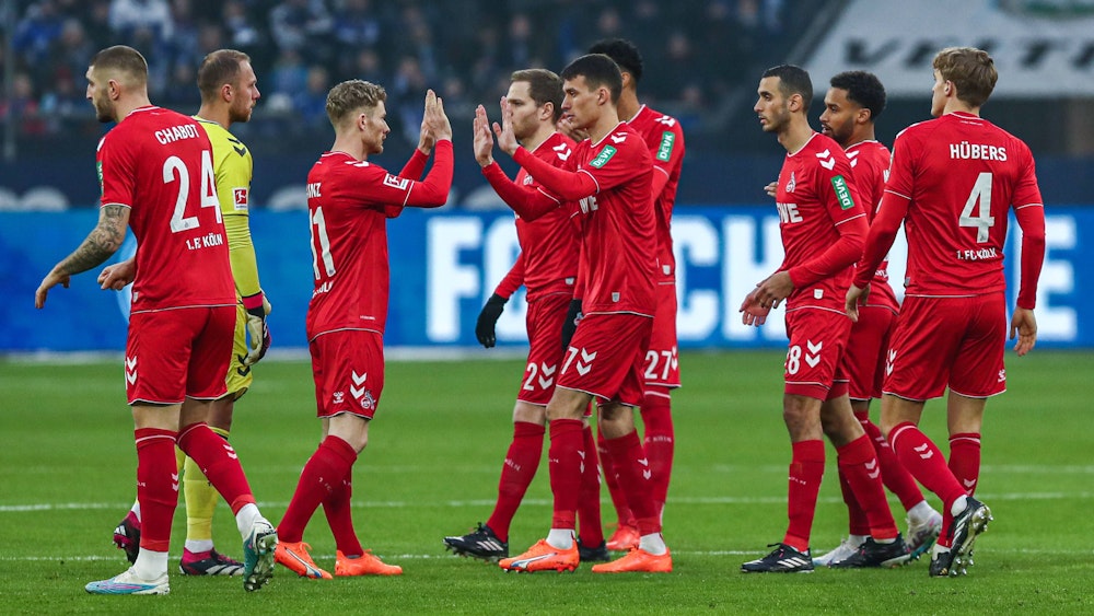 Anhänger des 1. FC Köln klatschen Schalke in einem Bundesligaspiel ab.