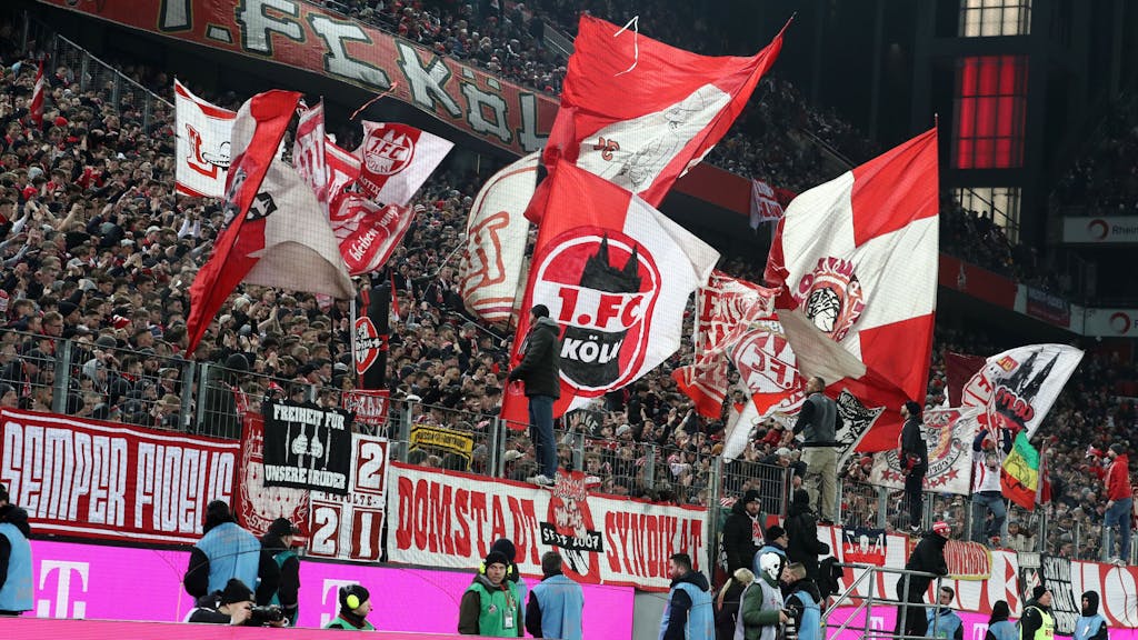Die Südkurve feiert nach dem Spiel die Mannschaft des 1. FC Köln. In der gefüllten Kurve wehen rot-weiße Fahnen.