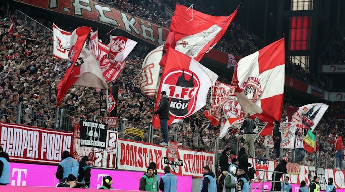 Die Südkurve feiert nach dem Spiel die Mannschaft des 1. FC Köln. In der gefüllten Kurve wehen rot-weiße Fahnen.