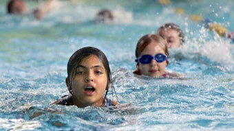Kinder schwimmen in einem Schwimmbad.