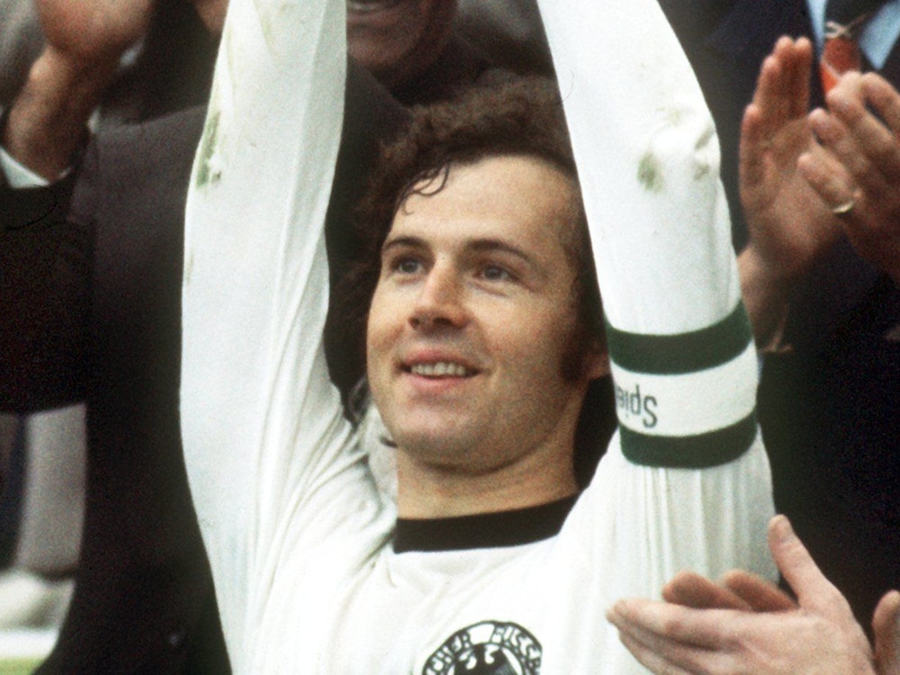 Glücklich hebt der deutsche Mannschaftskapitän Franz Beckenbauer bei der Siegerehrung im Münchner Olympiastadion für die Fußball-WM 1974 den eroberten WM-Pokal hoch.
