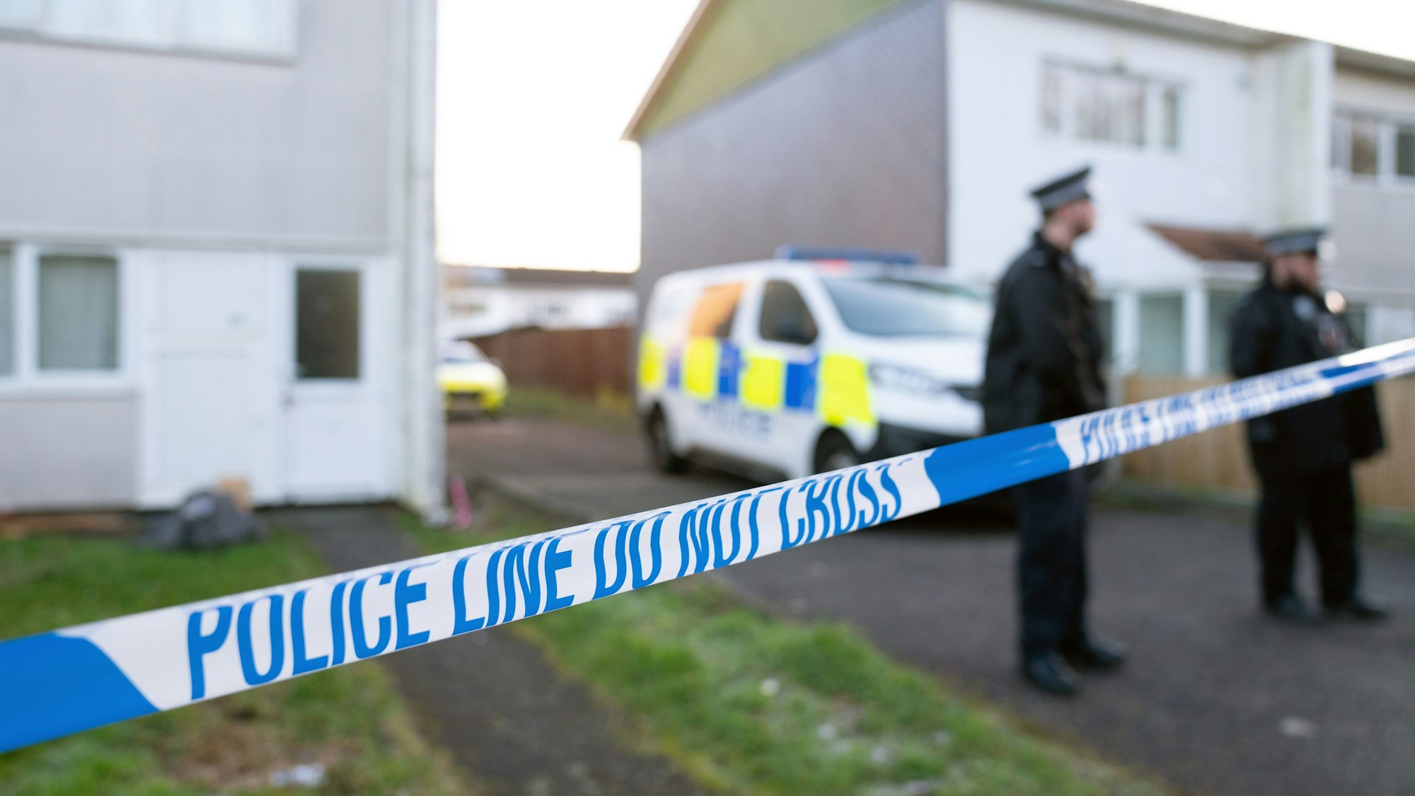 Britische Polizisten stehen an einem abgesperrten Tatort.