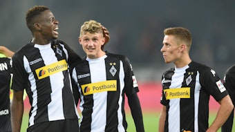 Denis Zakaria (l.), Michael Cuisance (M.) und Thorgan Hazard stehen nach dem Bundesliga-Spiel von Borussia Mönchengladbach gegen den VfB Stuttgart am 19. September 2017 in schwarz-weißen Gladbach-Trikots vor der Fankurve.