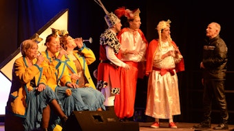 Premiere der alternativen Sitzung in der Abenteuerhalle Kalk. Schauspieler stehen in Kostümen auf der Bühne.