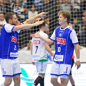 Dominik Mappes, Handballspieler des VfL Gummersbach, läuft bei einem Spiel mit ausgebreiteten Fänden auf seinen Mannschaftskollegen Finn Schroven zu.
