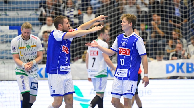 Dominik Mappes, Handballspieler des VfL Gummersbach, läuft bei einem Spiel mit ausgebreiteten Fänden auf seinen Mannschaftskollegen Finn Schroven zu.