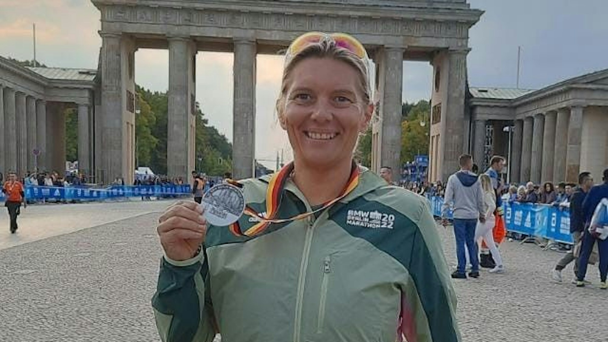 Die 45-Jährige lächelt in die Kamera und zeigt eine Medaille, nach einem absolvierten Marathon.