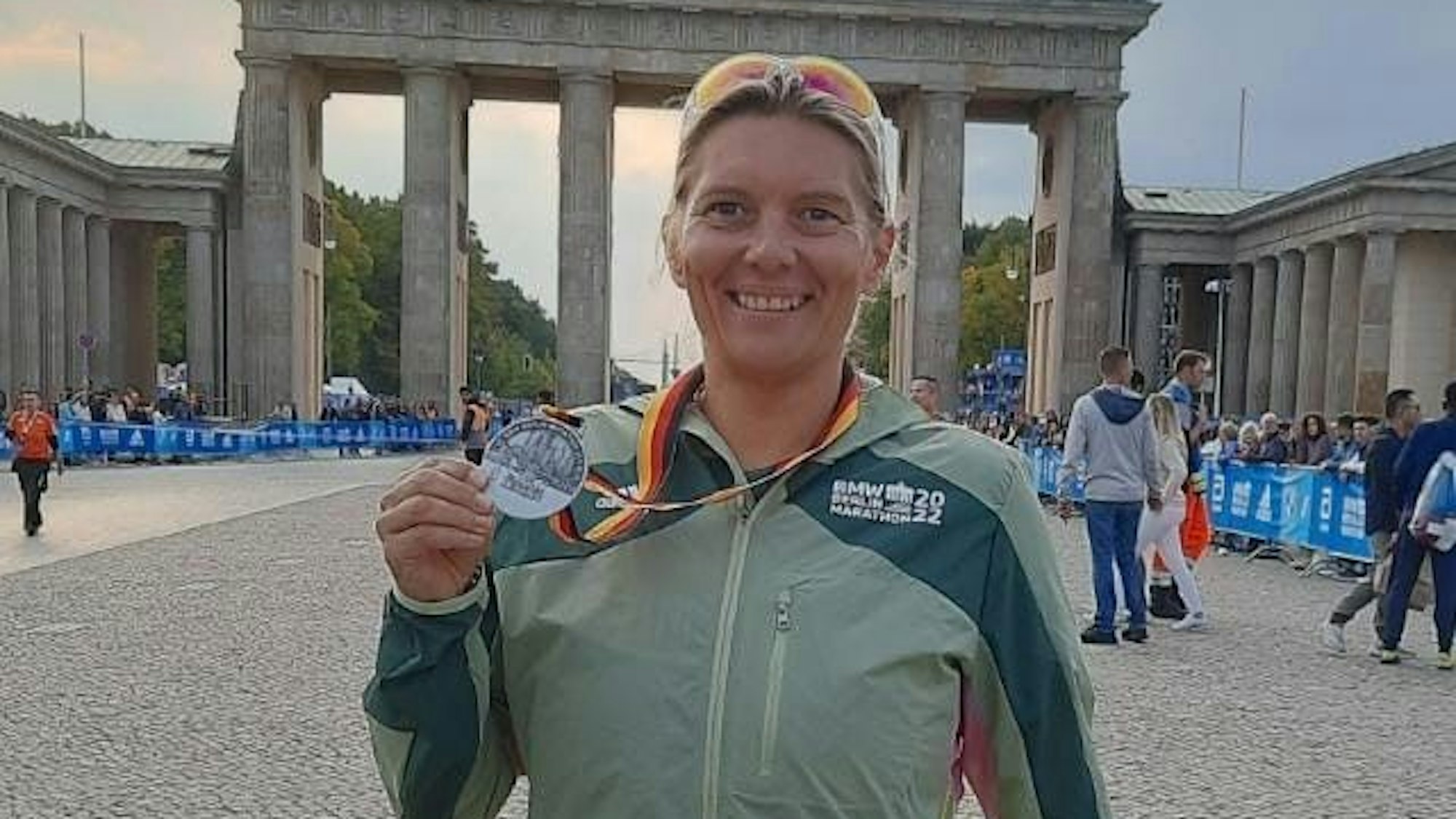 Ilona Schaffrath präsentiert vor dem Brandenburger Tor ihre Medaille des Berlin-Marathons.