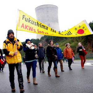 Das Archivfoto zeigt Demonstranten mit einem Transparent gegen Atomkraft vor dem Atomkraftwerk Tihange.