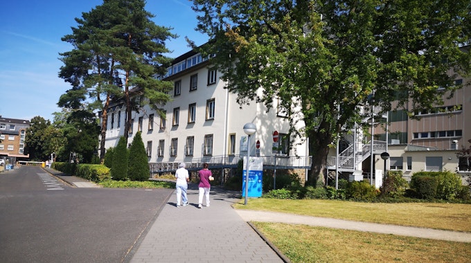 Das Foto zeigt das Krankenhaus Wesseling von außen. Zwei Frauen gehen Richtung Eingang.