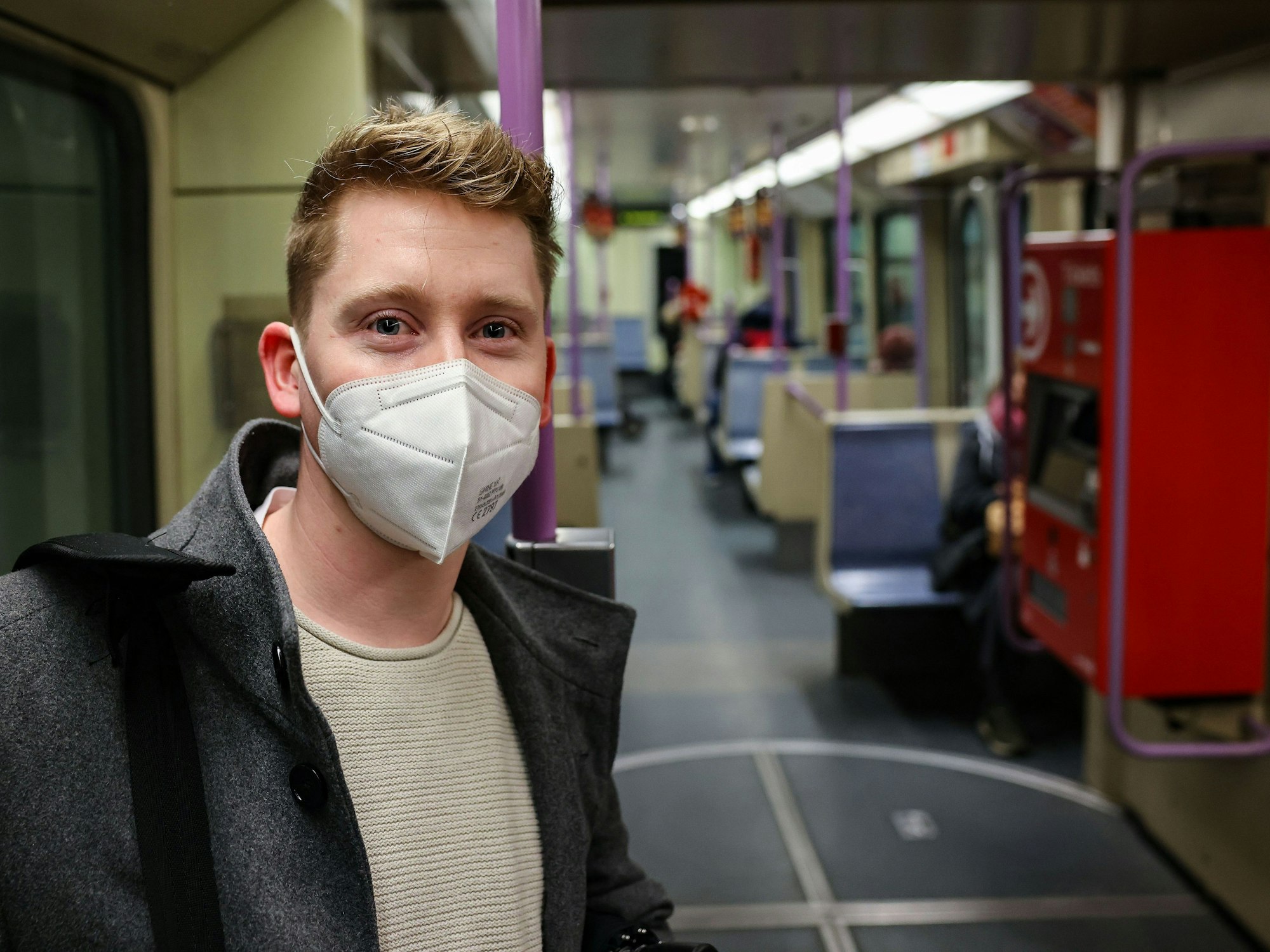 Matthias steht mit Maske in der U-Bahn.