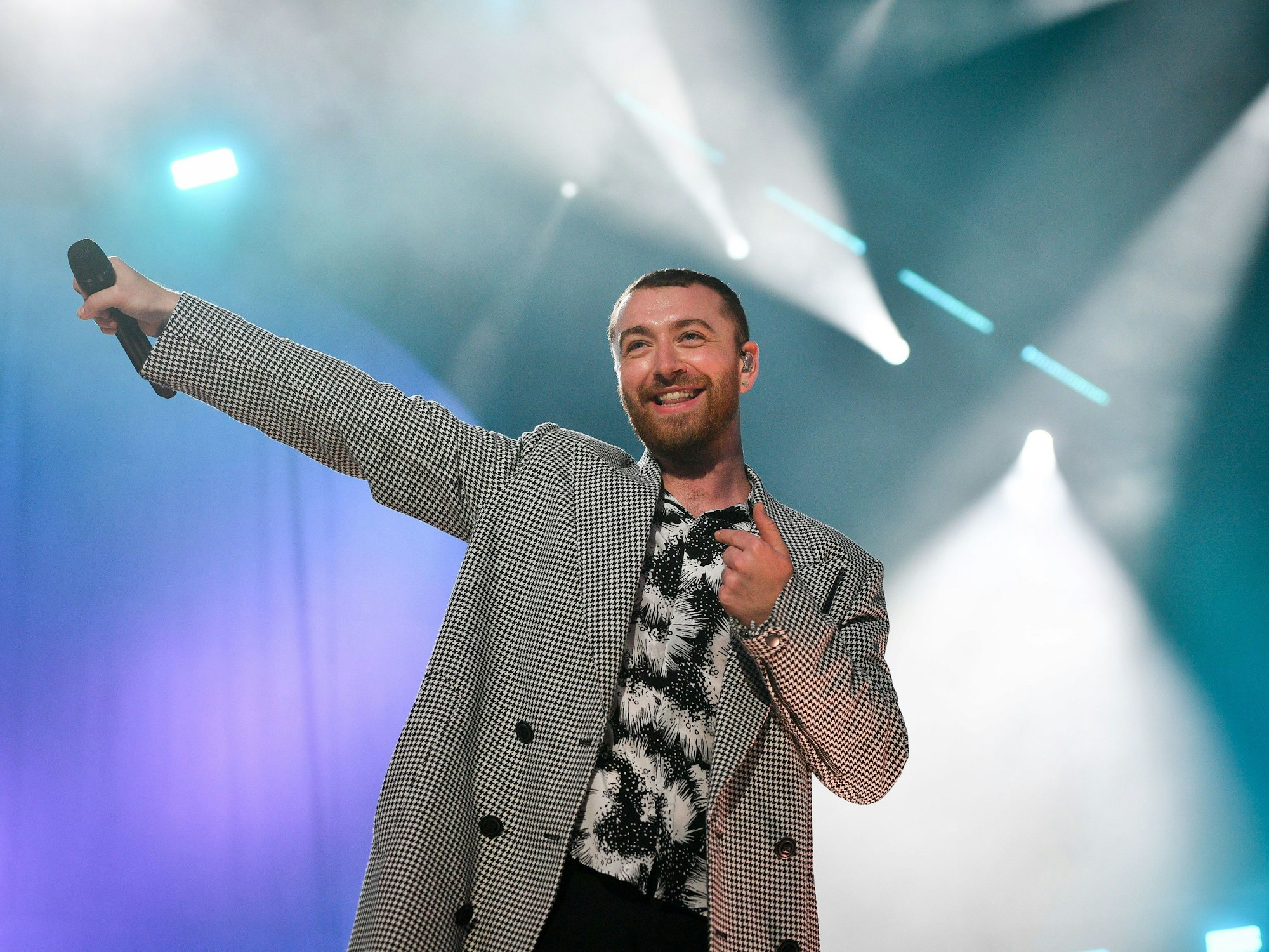 Sam Smith, hier im Mai 2018, steht in einem schwarz-weiß gemustertem Hemd und kariertem Jackett bei einem Festival in Großbritannien in Swansea auf der Bühne.
