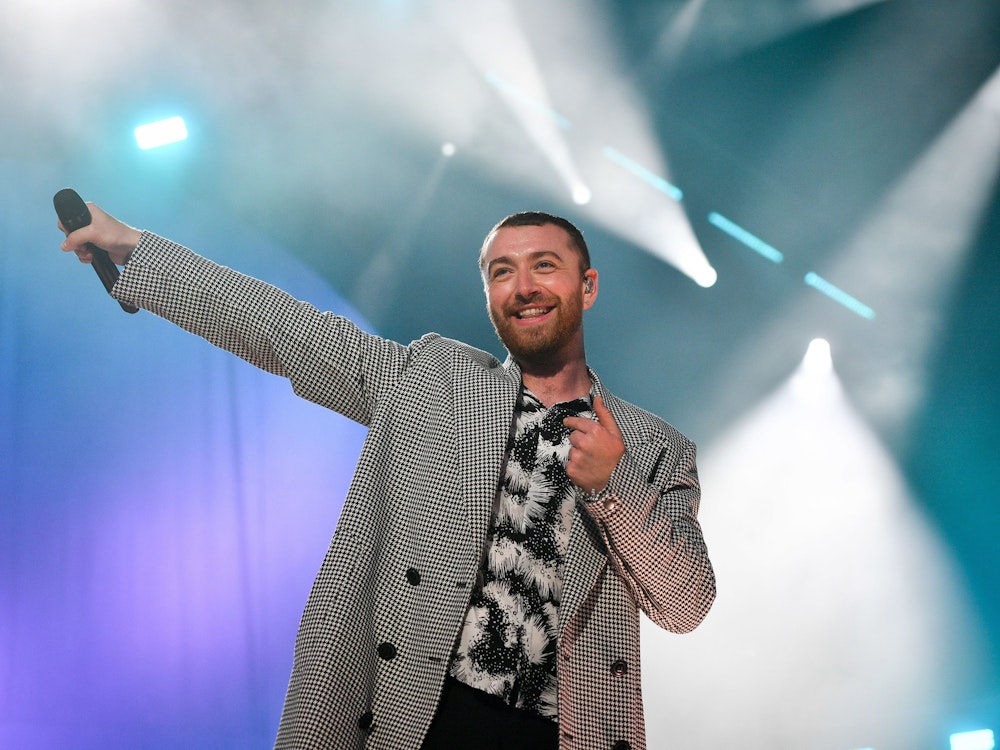 Sam Smith, hier im Mai 2018, steht in einem schwarz-weiß gemustertem Hemd und kariertem Jackett bei einem Festival in Großbritannien in Swansea auf der Bühne.