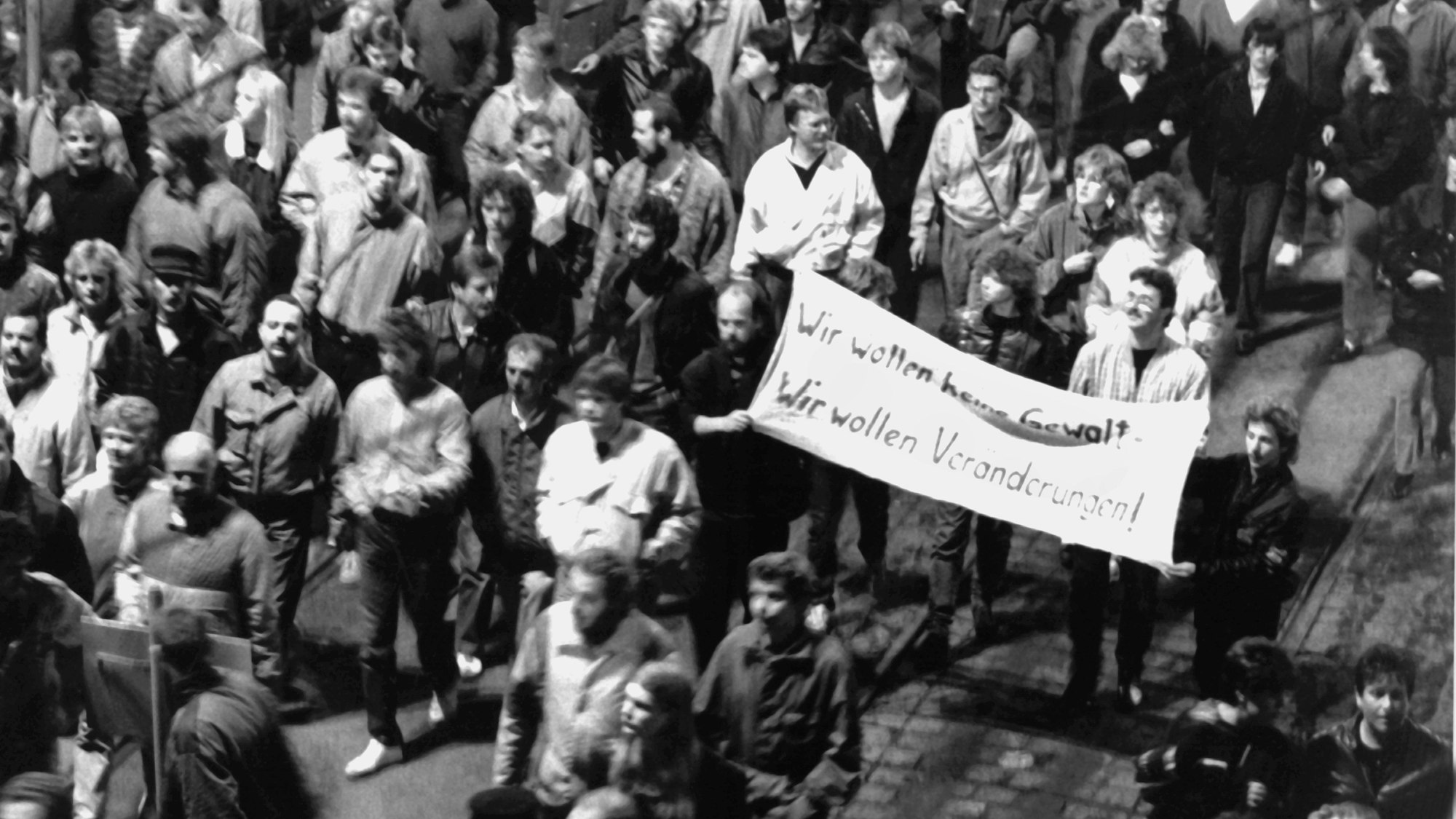 „Wir wollen keine Gewalt! Wir wollen Veränderungen!“ ist auf einem Transparent zu lesen, das Demonstranten bei der Montagsdemonstration am 9. Oktober 1989 in Leipzig mit sich führen.