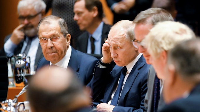 Wladimir Putin (M), Präsident von Russland, und Sergej Lawrow (l), Außenminister von Russland, sitzen im Bundeskanzleramt zu Beginn der Libyen-Konferenz. Ziel der Konferenz ist ein dauerhafter Waffenstillstand in dem Bürgerkriegsland. +++ dpa-Bildfunk +++