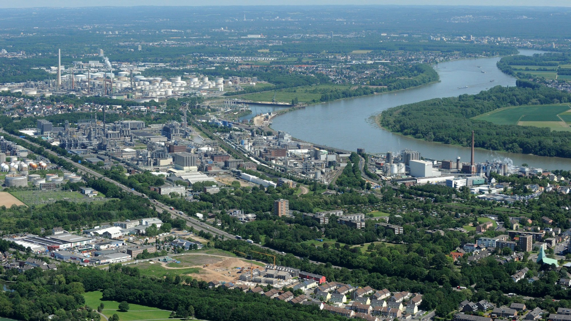 Ein Luftbild zeigt den Rhein bei Wesseling. Am Fluss befinden sich zahlreiche Industrieanlagen, unter anderem von Shell.