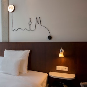 Ein Hotelzimmer mit einer Lichtleiste in Form des Köln-Panoramas über dem Bett
