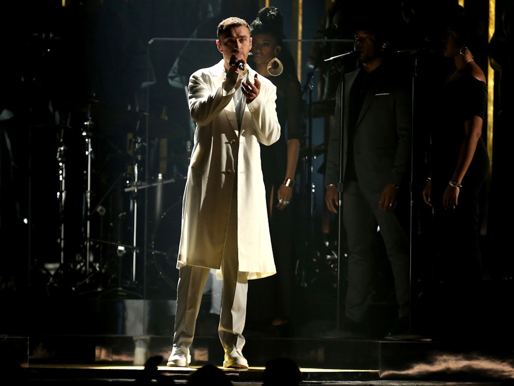 Sam Smith, hier im Januar 2018 auf der Bühne, tritt im Rahmen der Verleihung der 60. Grammy Awards im Madison Square Garden in New York auf. Der Sänger trägt einen langen beigen Mantel und eine beige Stoffhose.