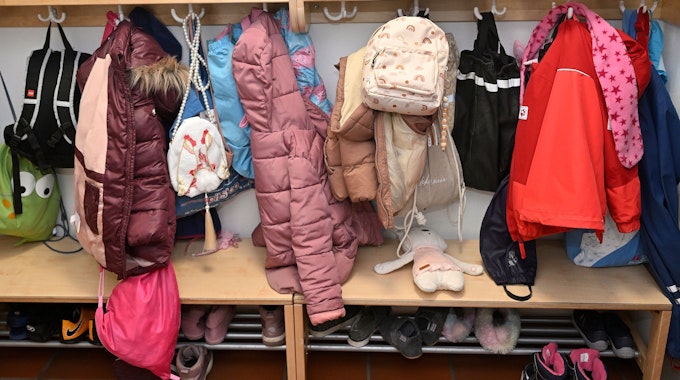 Jacken und Mäntel hängen an einer Garderobe in einer Kita.