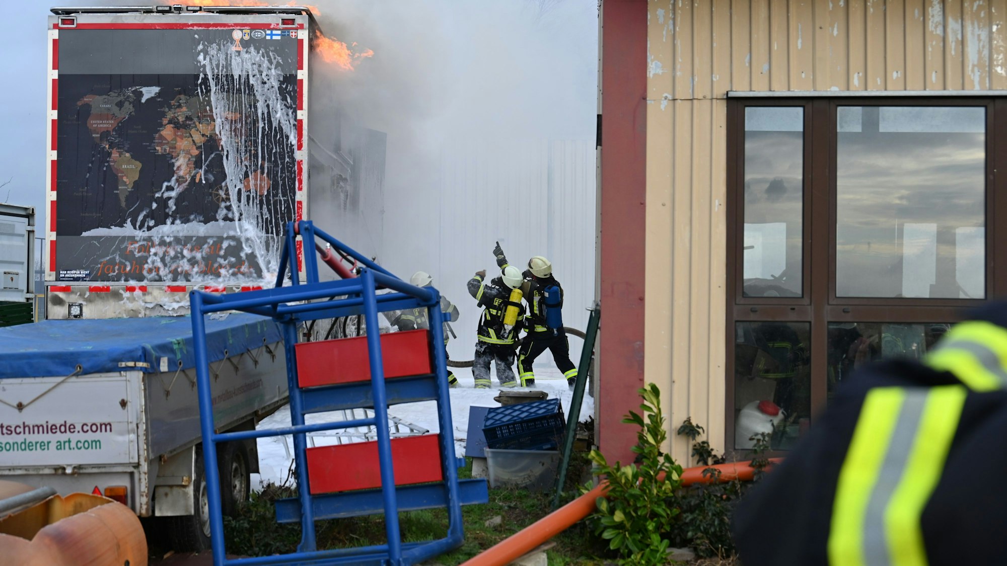 Das Bild zeigt Feuerwehrleute, die ein Wohnmobil löschen.