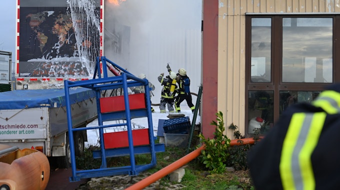 Das Bild zeigt Feuerwehrleute, die ein Wohnmobil löschen.