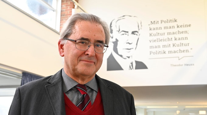 Klaus Füßmann steht vor einem Zitat von Theodor Heuss an einer Wand. Das Zitat lautet: „Mit Politik kann man keine Kultur machen, vielleicht kann man mit Kultur Politik machen.“