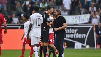 Gladbach-Trainer Daniel Farke (r.) im Gespräch mit Schiedsrichter Deniz Aytekin (l.), hier zu sehen am 4. September 2022, nach dem Bundesliga-Duell der Borussia gegen Mainz 05. Farke und Aytekin klatschen sich ab und diskutieren über einige Szenen.