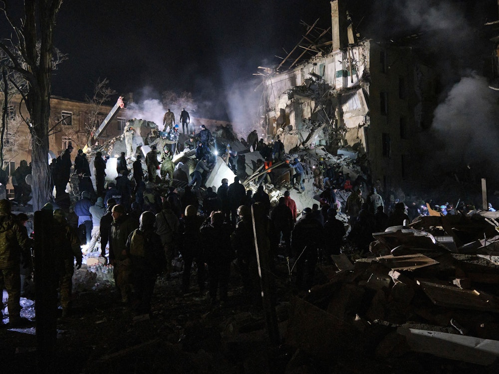 Rettungskräfte und Anwohner und Anwohnerinnen räumen die Trümmer nach dem Einschlag einer russischen Rakete in ein Wohnhaus.