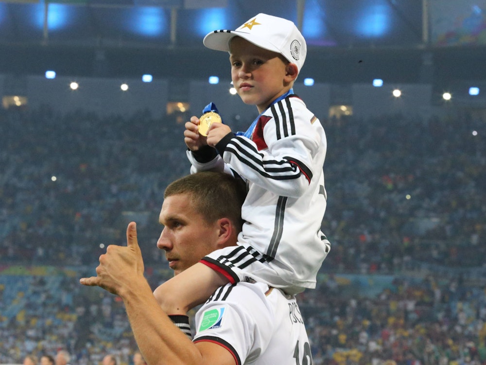 Lukas Podolski mit seinem Sohn Louis auf den Schultern.