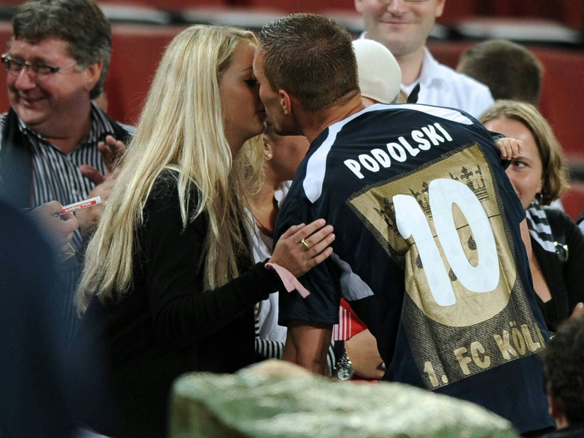 Lukas Podolski küsst seine Frau Monika.