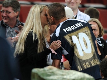Lukas Podolski küsst seine Frau Monika.