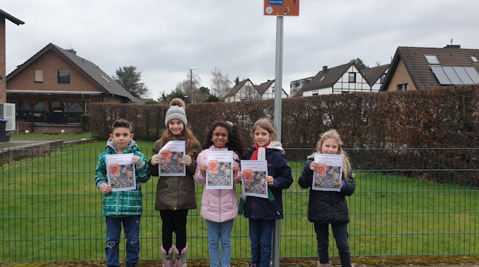 Fünf Grundschüler stehen an der Hol- und Bringzone an der Joseph-Schaeben-Schule in Weilerswist und halten jeweils ein Plakat in den den Händen.