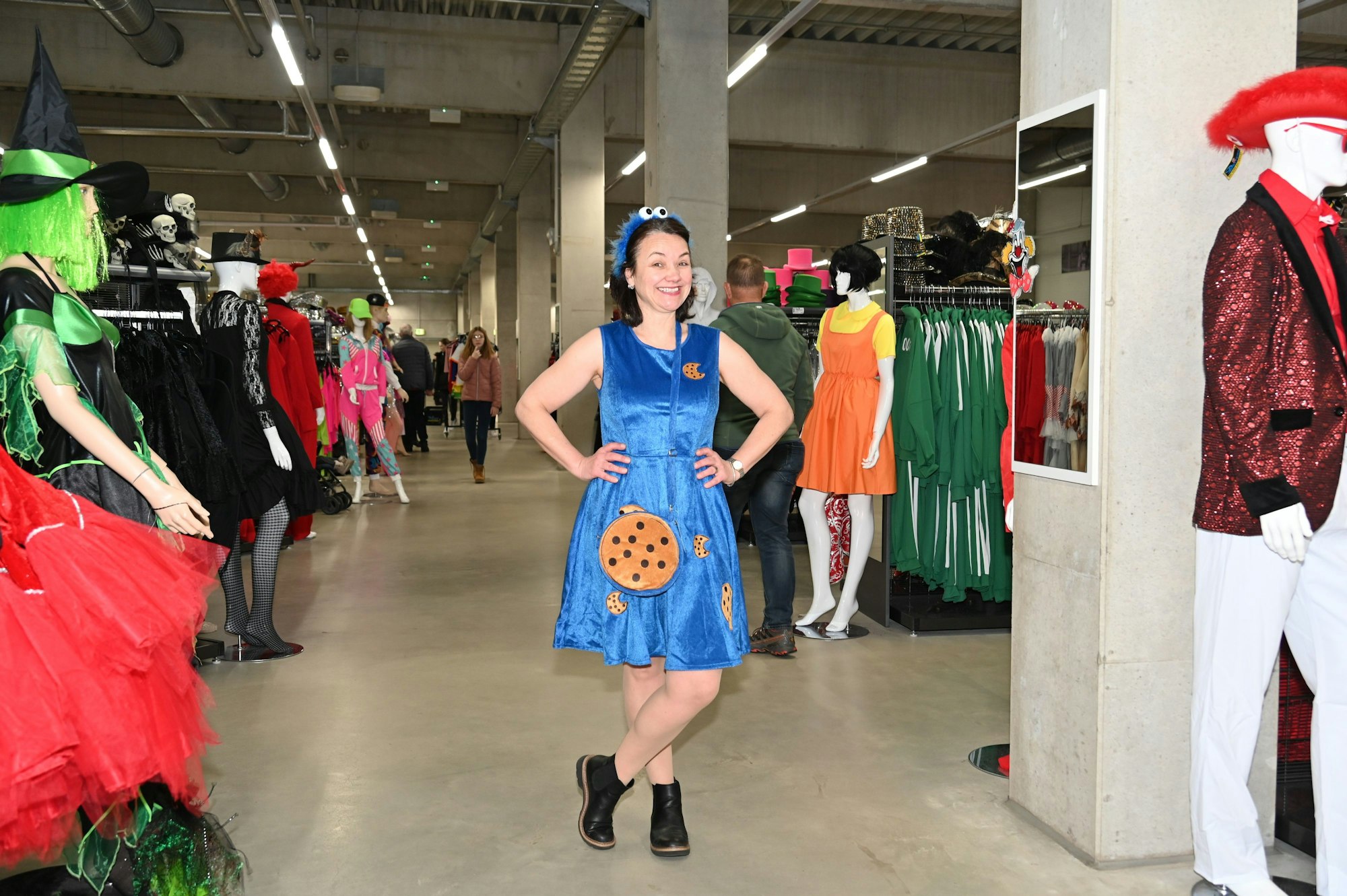 Eine Frau präsentiert ein Krümmelmonster-Kostüm in einem Verkleidungsladen.