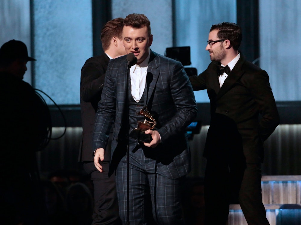 Sam Smith, hier im Februar 2015 im Staples Center in Los Angeles, steht in einem dunkelblau karierten Stoffanzug während der 57. Grammy Awards auf der Bühne. Dort beim er den Award für den besten Song des Jahres überreicht.