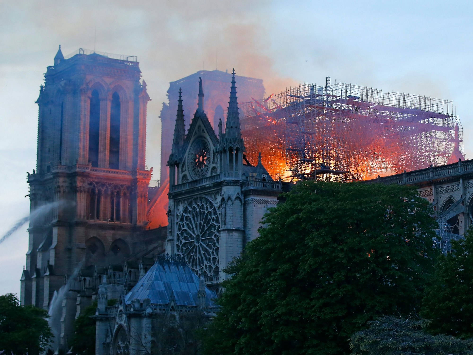 Das Foto vom 15. April 2019 zeigt die Pariser Kathedrale Notre-Dame, die in Flammen steht. Über ihr zieht Rauch hinweg.