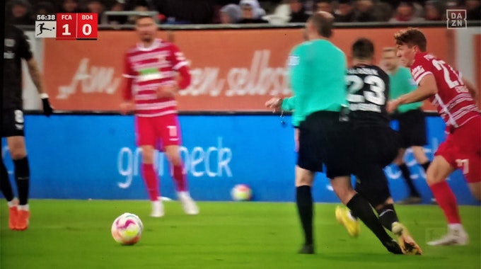 Bayer-Profi Adam Hlozek rennt im Auswärtsspiel beim FC Augsburg in Schiedsrichter Marco Fritz hinein.