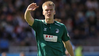 Aron Andreasson gibt Anweisungen im Trikot des VfB Lübeck und hebt dabei seinen rechten Arm.