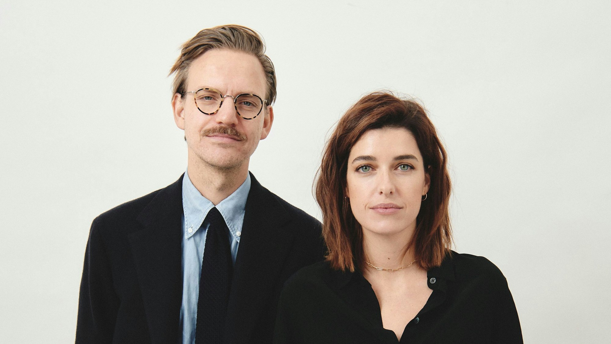 Sebastian Tigges und Marie Nasemann stehen in schicker, schwarzer Garderobe nebeneinander.