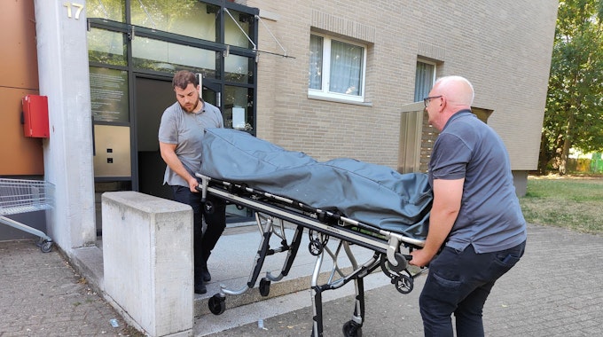Der Leichnam des erschossenen Mieters wird im August 2022 aus dem Wohnheim in Köln-Ostheim abtransportiert.